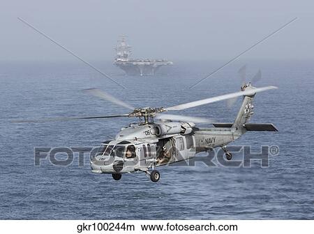A MH-60S Knighthawk conducts a vertical replenishment at sea. View Large Photo Image Picture - A MH-60S Knighthawk conducts a vertical replenishment at sea.. Fotosearch