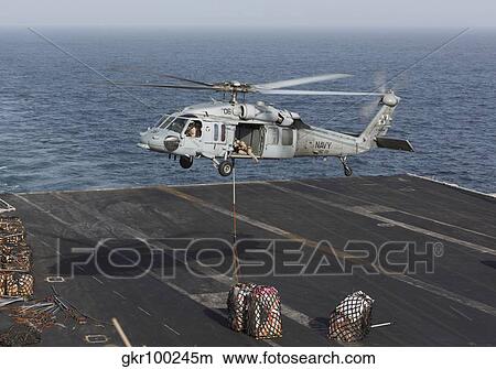 A MH-60S Knighthawk conducts a vertical replenishment at sea. View Large Photo Image Picture - A MH-60S Knighthawk conducts a vertical replenishment at sea.. Fotosearch