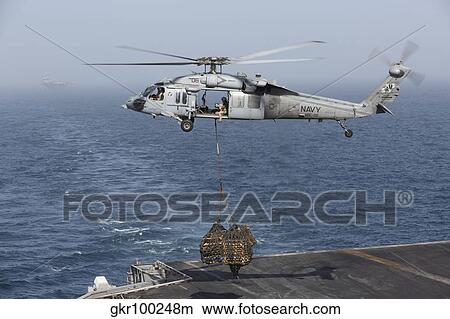 A MH-60S Knighthawk conducts a vertical replenishment at sea. View Large Photo Image Picture - A MH-60S Knighthawk conducts a vertical replenishment at sea.. Fotosearch