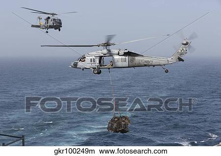 Picture - A MH-60S Knighthawk transfers cargo during a vertical replenishment.. Fotosearch