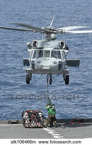 A MH-60S Sea Hawk helicopter lifts supplies from the fantail of USNS Amelia Earhart. View Large Photo Image Picture - A MH-60S Sea Hawk helicopter lifts supplies from the fantail of USNS Amelia Earhart.. Fotosearch