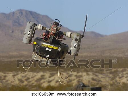 A Micro Air Vehicle flies over a simulated combat area. View Large Photo Image Picture - A Micro Air Vehicle flies over a simulated combat area.. Fotosearch
