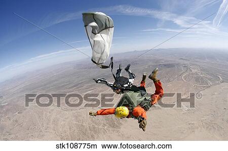 A military freefall parachutist deploys his parachute during a HALO jump. View Large Photo Image Picture - A military freefall parachutist deploys his parachute during a HALO jump.. Fotosearch