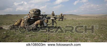 Picture - A mortarman with the U. S. Marine Corps fires an M4 carbine.. Fotosearch