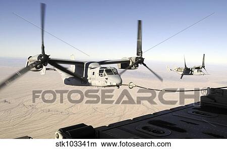 A MV-22 Osprey refuels midflight while another waits its turn. View Large Photo Image Picture - A MV-22 Osprey refuels midflight while another waits its turn.. Fotosearch