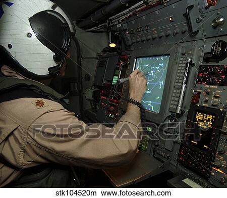 A Naval Flight Officer tracks aircraft at his station on an E-2C Hawkeye. View Large Photo Image Picture - A Naval Flight Officer tracks aircraft at his station on an E-2C Hawkeye.. Fotosearch