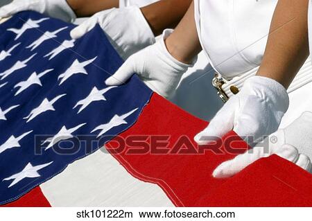 A Naval Station Pearl Harbor Ceremonial Guard folds the National Ensign during a burial ceremony. View Large Photo Image Picture - A Naval Station Pearl Harbor Ceremonial Guard folds the National Ensign during a burial ceremony.. Fotosearch