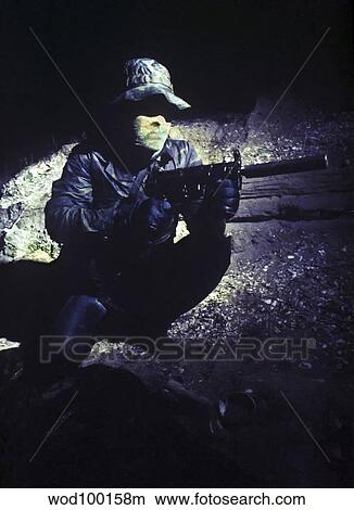 Picture - A Navy SEAL provides security with a MP5 submachine gun.. Fotosearch