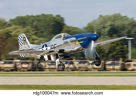 A P-51 Mustang takes off from Oshkosh, Wisconsin. View Large Photo Image Picture - A P-51 Mustang takes off from Oshkosh, Wisconsin.. Fotosearch