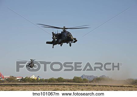 Picture - A pair of AH-64D Apache Longbow helicopters taking off.. Fotosearch