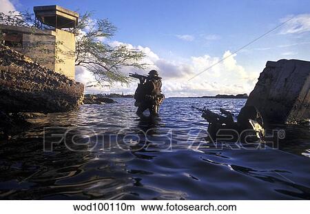 A pair of Navy SEAL combat swimmers transition from underwater to the surface. View Large Photo Image Picture - A pair of Navy SEAL combat swimmers transition from underwater to the surface.. Fotosearch