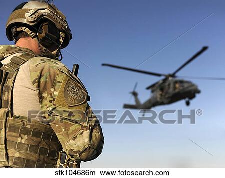 A pararescueman awaits the landing of an HH-60 Pave Hawk. View Large Photo Image Picture - A pararescueman awaits the landing of an HH-60 Pave Hawk.. Fotosearch
