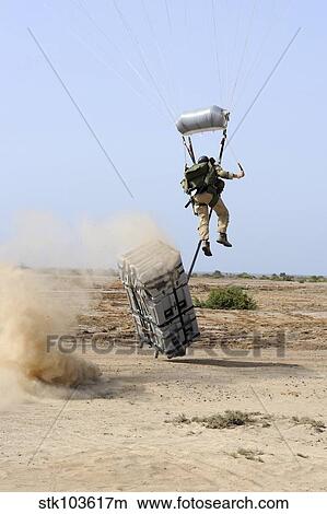 A pararescueman drops into the zone trailing his team's rescue supplies outside of Camp Lemonier, Djibouti. View Large Photo Image Picture - A pararescueman drops into the zone trailing his team's rescue supplies outside of Camp Lemonier, Djibouti.. Fotosearch