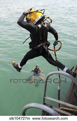A photographer documents a Navy diver as he enters the water. View Large Photo Image Picture - A photographer documents a Navy diver as he enters the water.. Fotosearch