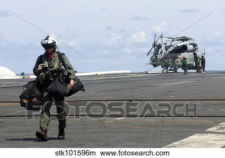 A pilot walks across the flight deck of USS Kitty Hawk. View Large Photo Image Picture - A pilot walks across the flight deck of USS Kitty Hawk.. Fotosearch