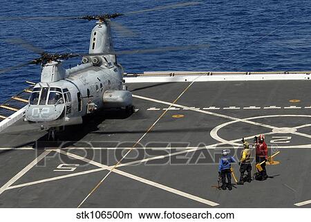 A plane captain signals to a CH-46E Sea Knight helicopter. View Large Photo Image Picture - A plane captain signals to a CH-46E Sea Knight helicopter.. Fotosearch