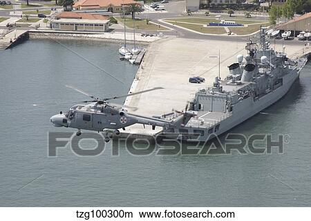 A Portuguese Navy Lynx helicopter flying over the harbor. View Large Photo Image Picture - A Portuguese Navy Lynx helicopter flying over the harbor.. Fotosearch