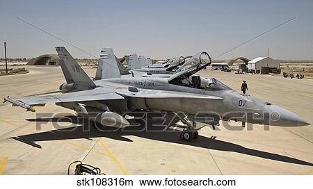 A row of U. S. Marine Corps F-18 Hornets await post-flight maintenance. View Large Photo Image Picture - A row of U. S. Marine Corps F-18 Hornets await post-flight maintenance.. Fotosearch