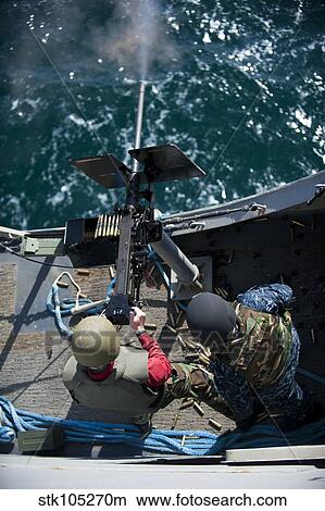 A sailor fires a. 50-caliber machine gun aboard USS New Orleans. View Large Photo Image Picture - A sailor fires a. 50-caliber machine gun aboard USS New Orleans.. Fotosearch