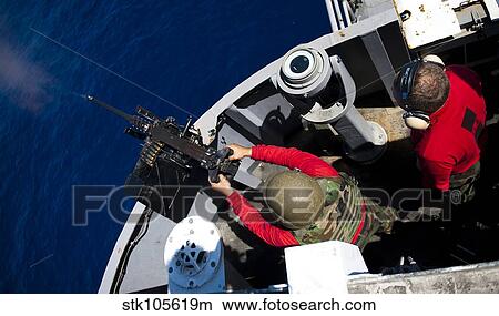 Picture - A Sailor fires a. 50-caliber machine gun aboard USS John C. Stennis.. Fotosearch