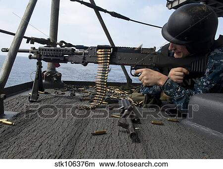 A Sailor fires an M-240B machine gun aboard USS Enterprise. View Large Photo Image Picture - A Sailor fires an M-240B machine gun aboard USS Enterprise.. Fotosearch