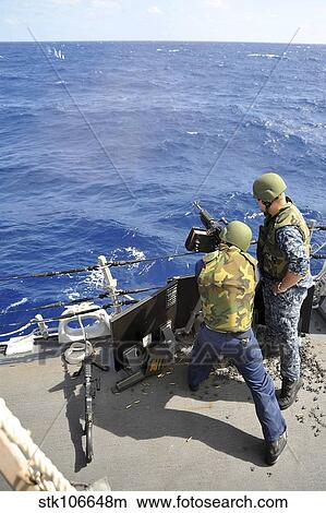 A sailor fires an M240B machine gun aboard USS McCampbell. View Large Photo Image Picture - A sailor fires an M240B machine gun aboard USS McCampbell.. Fotosearch