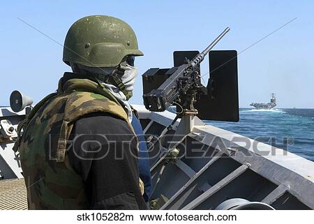 Picture - A sailor manning a. 50-caliber machine gun aboard USS Cape St. George.. Fotosearch