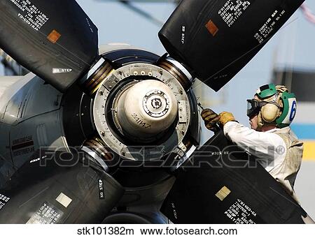 A Sailor performs maintenance on the propeller of an E-2C Hawkeye. View Large Photo Image Picture - A Sailor performs maintenance on the propeller of an E-2C Hawkeye.. Fotosearch
