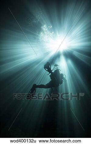 A scuba diver ascends into the light emanating above. View Large Photo Image Stock Photograph - A scuba diver ascends into the light emanating above.. Fotosearch