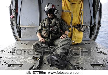 Picture - A search and rescue swimmer sits in the back of an MH-60S Sea Hawk.. Fotosearch