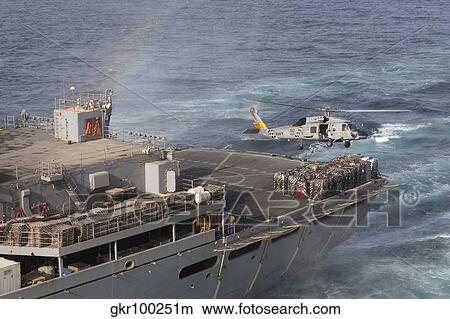 A SH-60J Seahawk conducts a vertical replenishment with USNS Supply. View Large Photo Image Picture - A SH-60J Seahawk conducts a vertical replenishment with USNS Supply.. Fotosearch