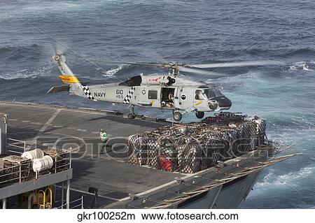 Picture - A SH-60J Seahawk conducts a vertical replenishment with USNS Supply.. Fotosearch