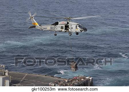 Picture - A SH-60J Seahawk conducts a vertical replenishment with USNS Supply.. Fotosearch