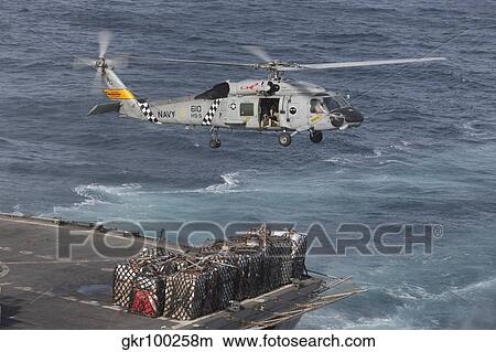 Picture - A SH-60J Seahawk conducts a vertical replenishment with USNS Supply.. Fotosearch