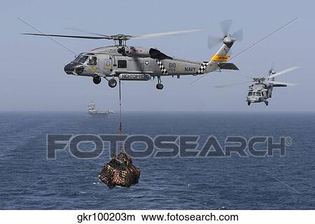 A SH-60J Seahawk transfers cargo during a vertical replenishment. View Large Photo Image Picture - A SH-60J Seahawk transfers cargo during a vertical replenishment.. Fotosearch