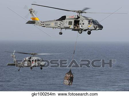 A SH-60J Seahawk transfers cargo during a vertical replenishment. View Large Photo Image Picture - A SH-60J Seahawk transfers cargo during a vertical replenishment.. Fotosearch