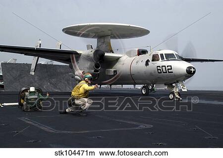 Picture - A shooter gives the signal to launch an E-2C Hawkeye.. Fotosearch