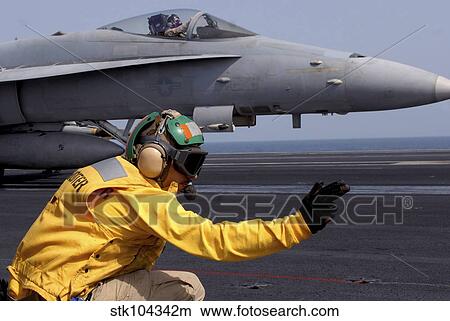 A shooter launches an F/A-18E Super Hornet from USS Ronald Reagan. View Large Photo Image Picture - A shooter launches an F/A-18E Super Hornet from USS Ronald Reagan.. Fotosearch