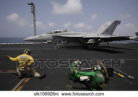 A shooter signals for the launching of an F/A-18F Super Hornet. View Large Photo Image Picture - A shooter signals for the launching of an F/A-18F Super Hornet.. Fotosearch