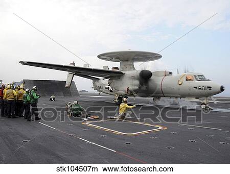 A shooter signals the launch of an E-2C Hawkeye aboard USS Abraham Lincoln. View Large Photo Image Picture - A shooter signals the launch of an E-2C Hawkeye aboard USS Abraham Lincoln.. Fotosearch