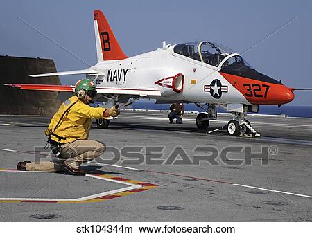 A shooter signlas the launch of a T-45A Goshawk trainer aircraft. View Large Photo Image Picture - A shooter signlas the launch of a T-45A Goshawk trainer aircraft.. Fotosearch