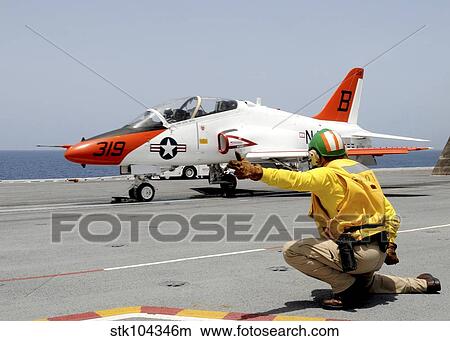 A shooter signlas the launch of a T-45A Goshawk trainer aircraft. View Large Photo Image Picture - A shooter signlas the launch of a T-45A Goshawk trainer aircraft.. Fotosearch