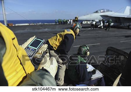 A Shooter tests a catapult capacity selector valve calculator during flight operations. View Large Photo Image Picture - A Shooter tests a catapult capacity selector valve calculator during flight operations.. Fotosearch