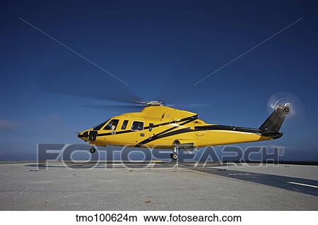 A Sikorsky S-76 utility helicopter taking off from an oil rig. View Large Photo Image Picture - A Sikorsky S-76 utility helicopter taking off from an oil rig.. Fotosearch