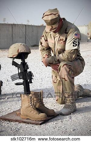 A soldier bows to pay tribute to a fallen soldier. View Large Photo Image Picture - A soldier bows to pay tribute to a fallen soldier.. Fotosearch