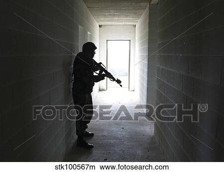 A soldier clears a hallway in a building at a Military Operation in Urban Terrain training facility. View Large Photo Image Picture - A soldier clears a hallway in a building at a Military Operation in Urban Terrain training facility.. Fotosearch