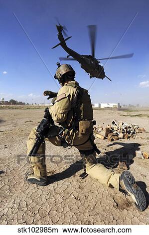 A soldier conducts security for an HH-60 Pavehawk helicopter. View Large Photo Image Picture - A soldier conducts security for an HH-60 Pavehawk helicopter.. Fotosearch