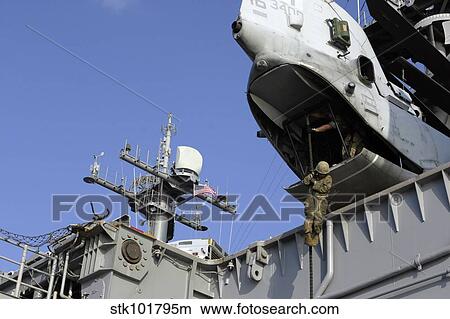 A soldier fast-ropes from the rear of a CH-46E Sea Knight. View Large Photo Image Picture - A soldier fast-ropes from the rear of a CH-46E Sea Knight.. Fotosearch