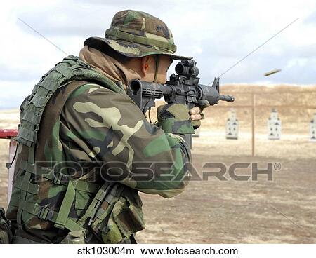 A soldier fires rounds down range at an M-4 qualification shoot. View Large Photo Image Picture - A soldier fires rounds down range at an M-4 qualification shoot.. Fotosearch