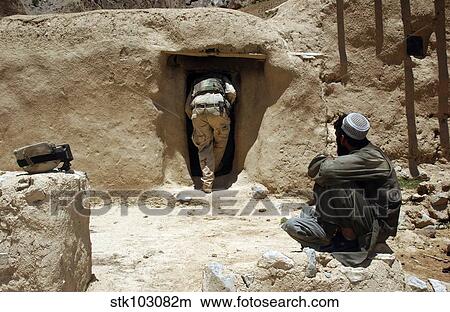 Picture - A soldier from the National Guard searches the home of a suspected Taliban member in Afghanistan.. Fotosearch